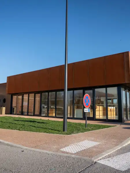 Bâtiment moderne avec façade rouille et toiture orangée, architecture contemporaine au port de plaisance d'Aire-sur-la-Lys